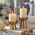 Gold metal pillar candle holder set with graduated heights.