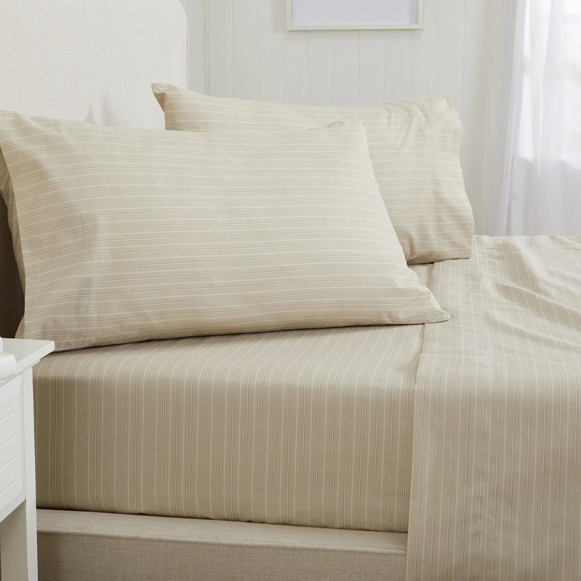 Great Bay Home Stripe Sheet Set from Adeline Collection in beige with thin white stripes on a bed; includes two pillowcases.
