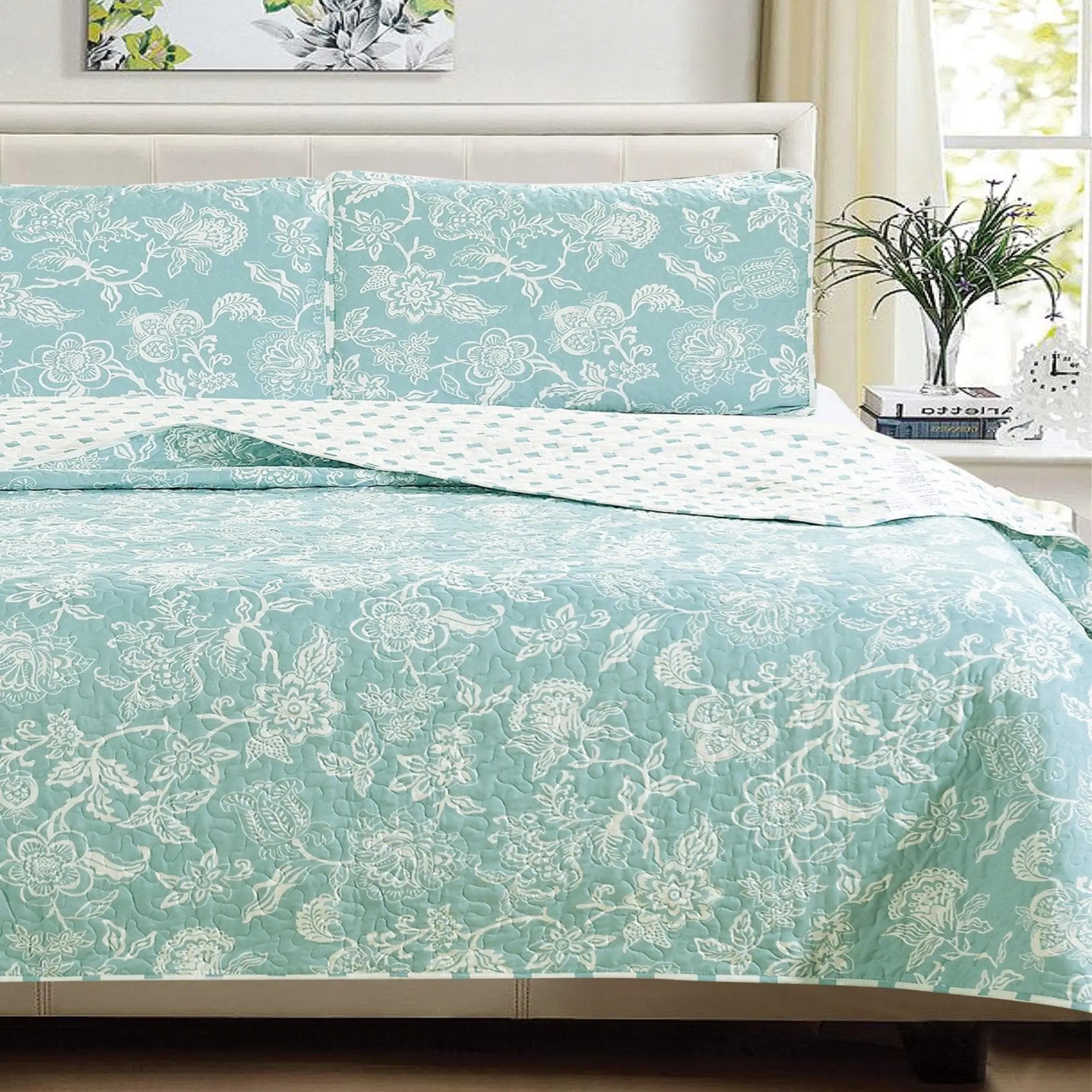 Floral Quilt Emma Collection by Great Bay Home; turquoise quilt with white floral pattern and matching shams on bed.