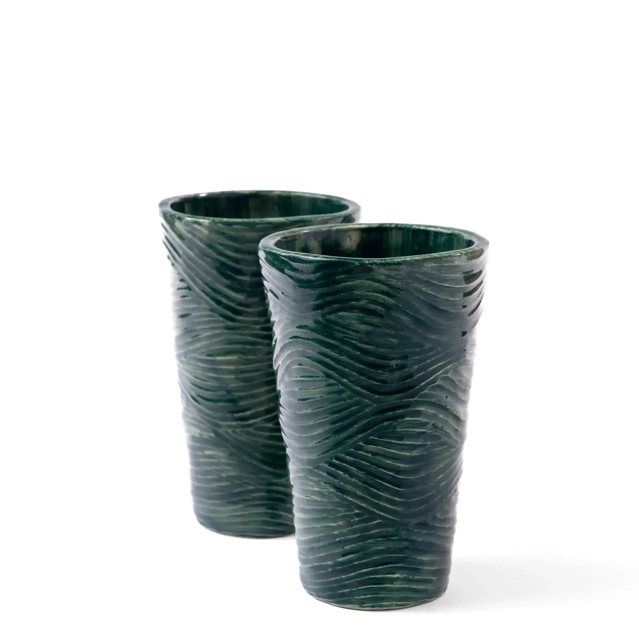 Rim and base closeup of green and blue coastal pattern glass tumblers.