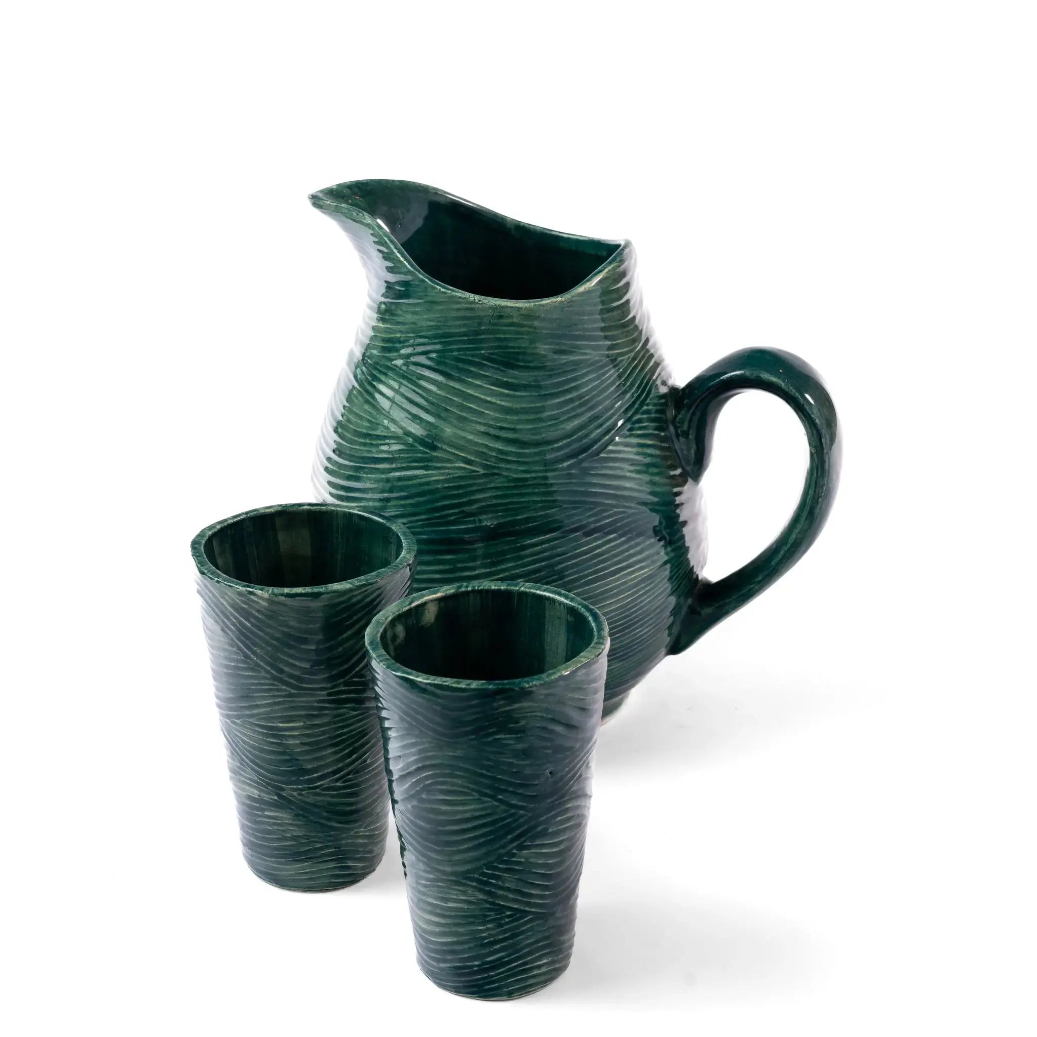 Green coastal pattern glass tumbler on a tabletop.