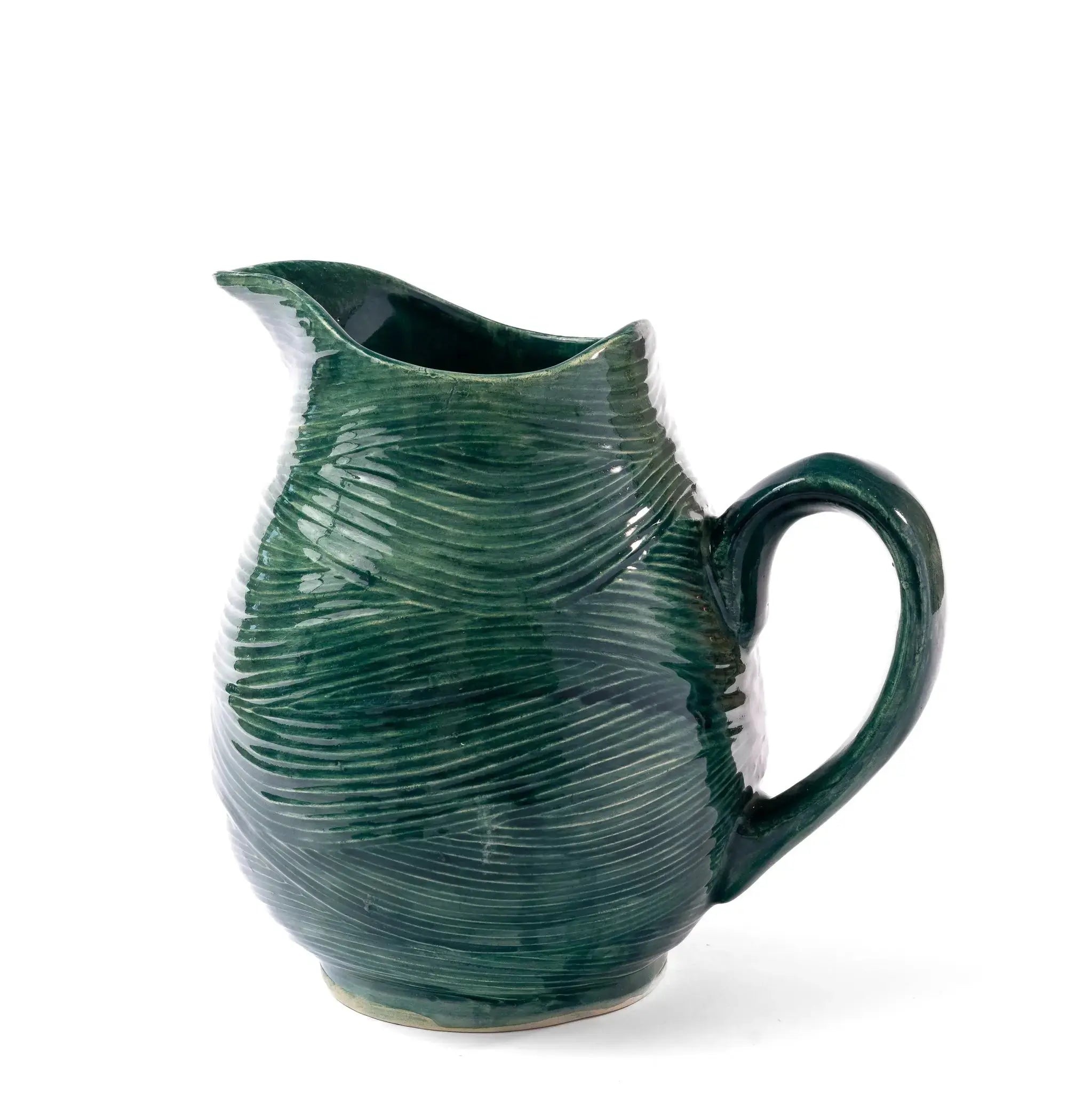 Green coastal pitcher styled on a dining table in a beach house dining room