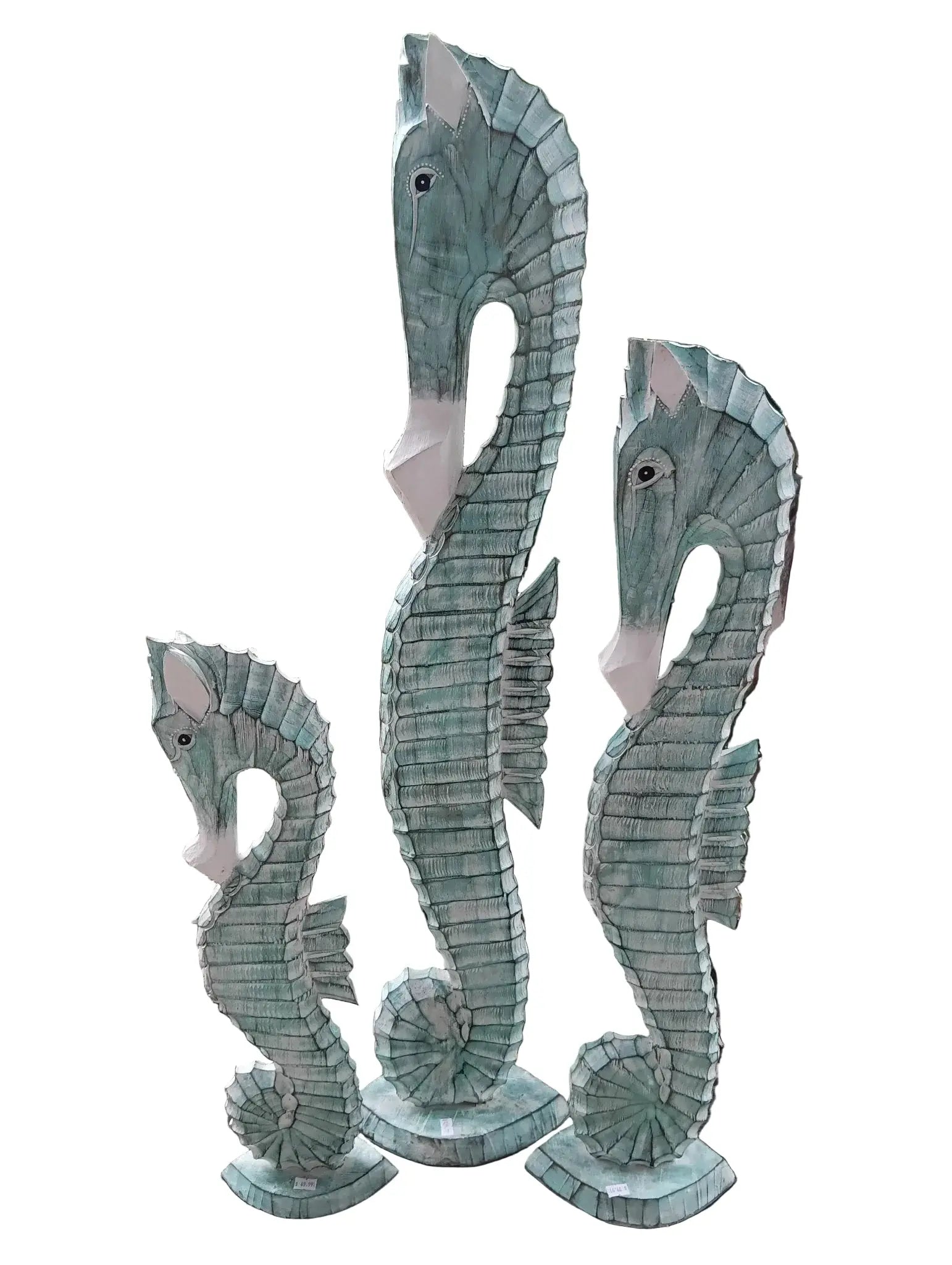 Three hand-carved wooden seahorses in ocean blue and teal hues for coastal decor.