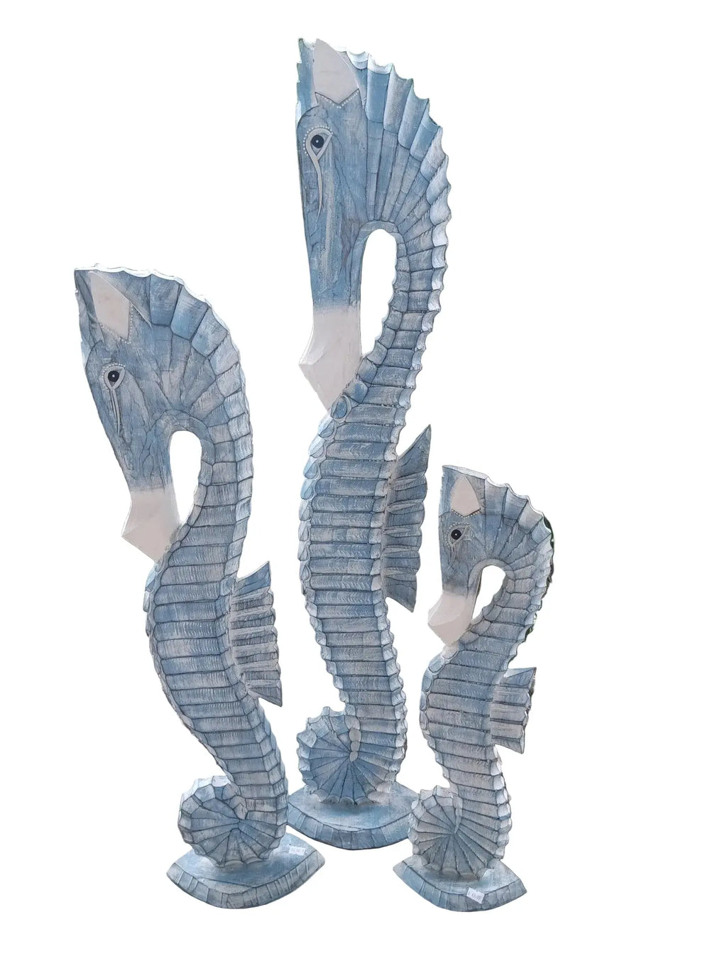 Three hand-carved coastal wood seahorses in ocean blue and teal tones.