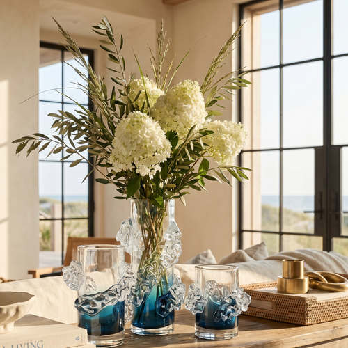 Small wavy blue and clear glass bud vase used for minimalist modern shelf styling
