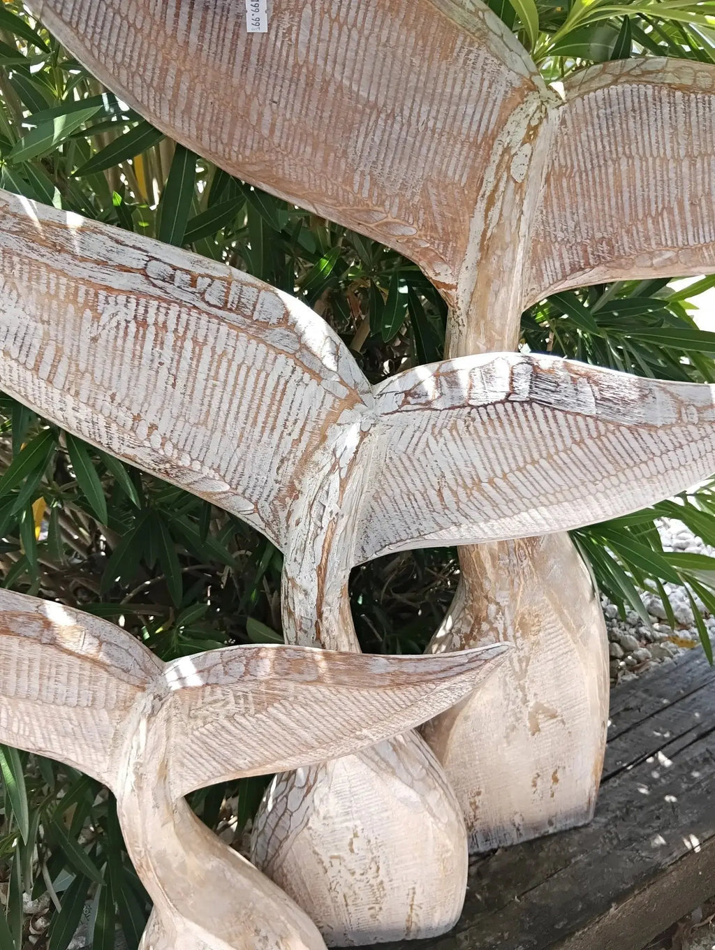 Large whitewashed wooden whale tail for airy coastal living room decor.