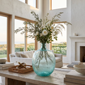 Light blue glass vase filled with fresh flowers styled on a coffee table.