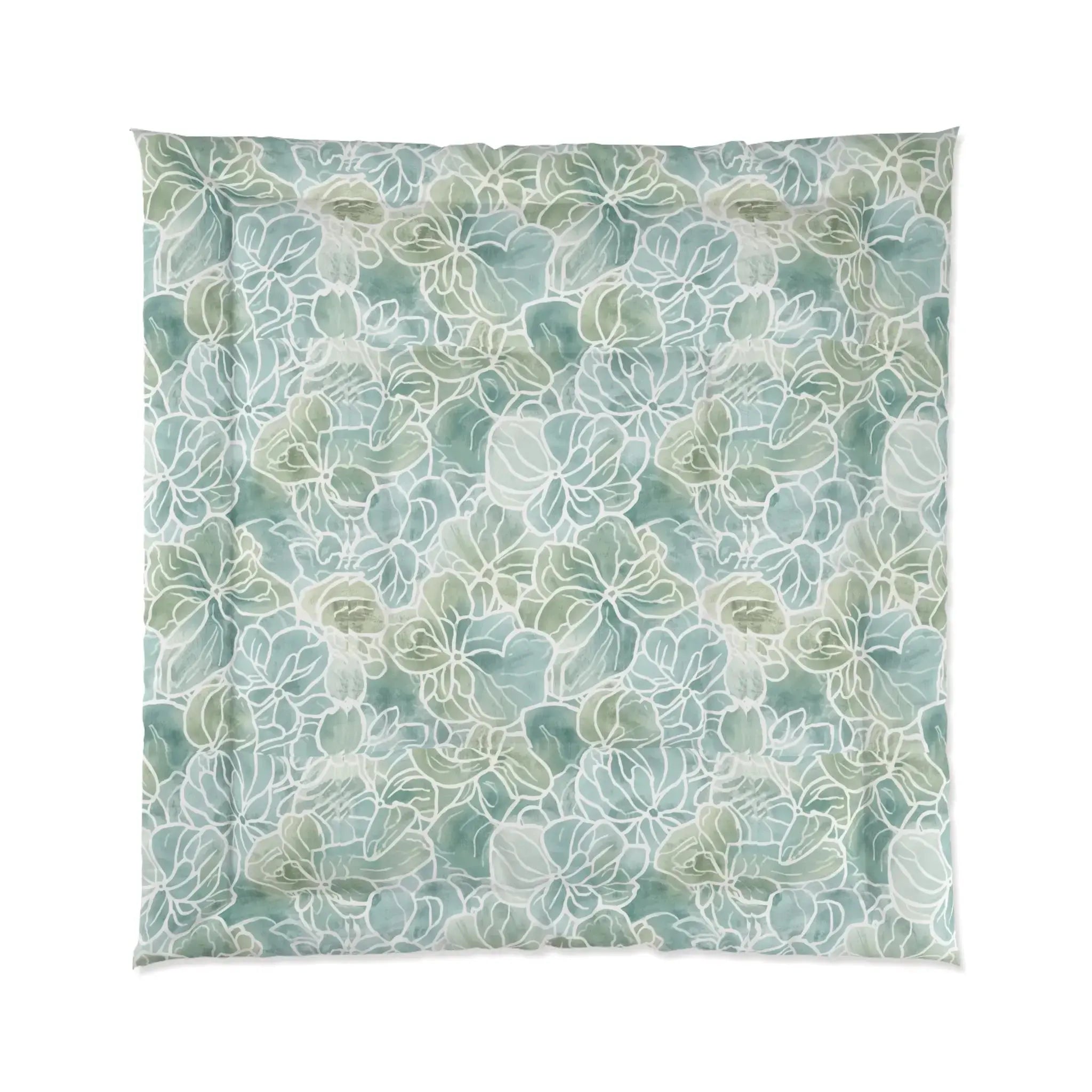 Light blue/green floral comforter set layered with white pillows in a relaxed coastal bedroom