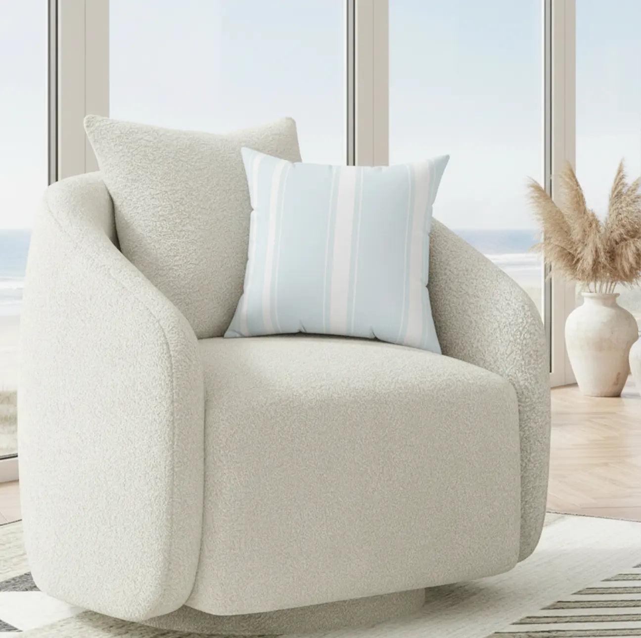 Southampton Stripe Throw Pillow in light blue nautical stripes on a cream boucle chair.