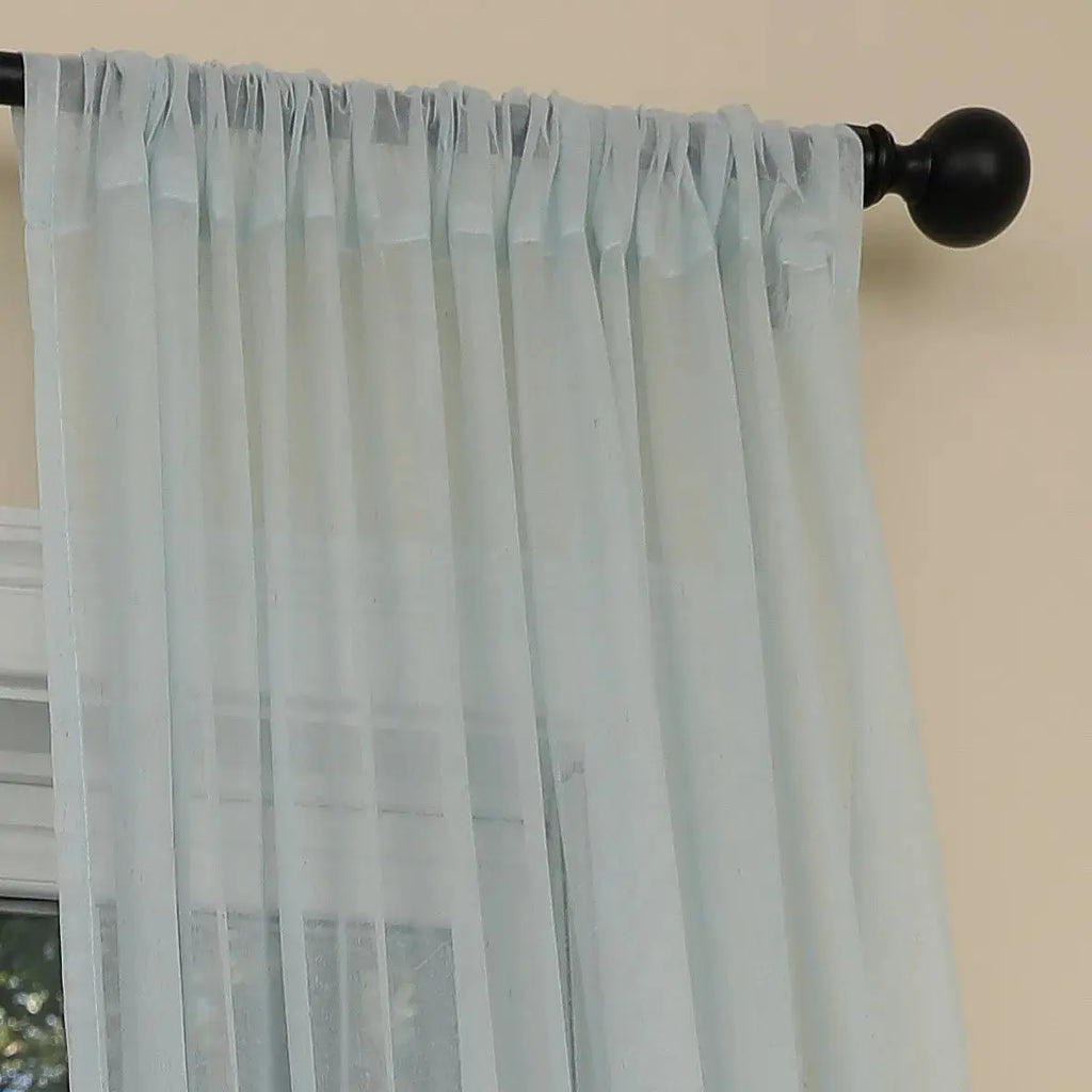 Closeup of ocean coral design on light blue semi sheer curtain fabric