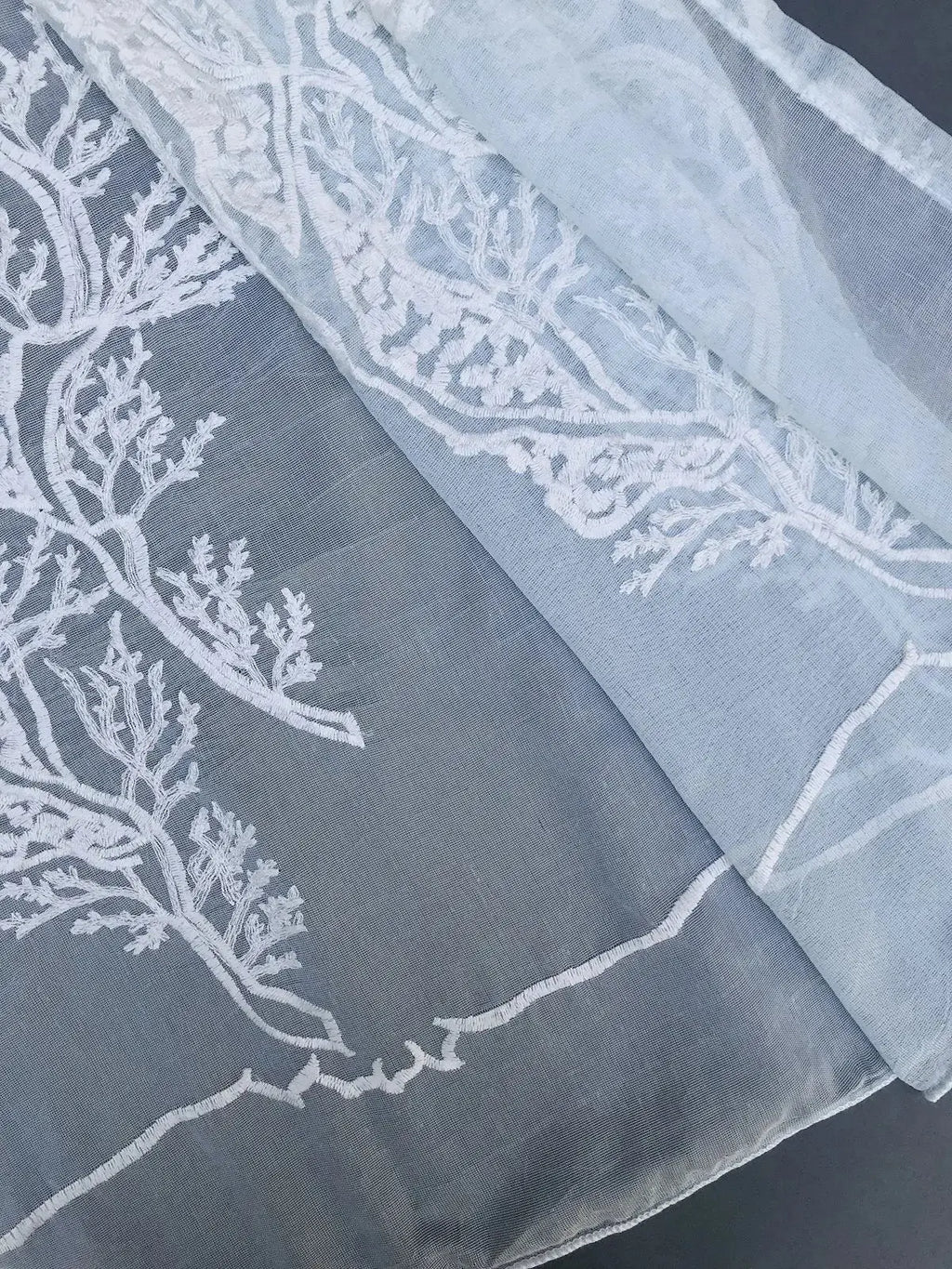 Closeup of hem and stitching detail on light blue ocean coral semi sheer curtain