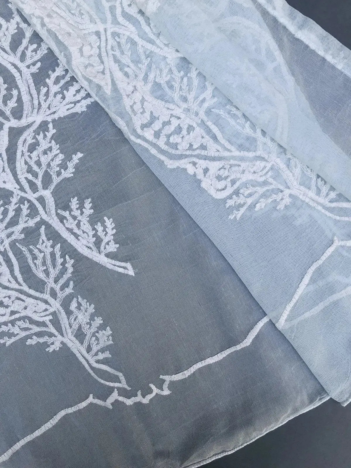 Closeup of hem and stitching detail on light blue ocean coral semi sheer curtain