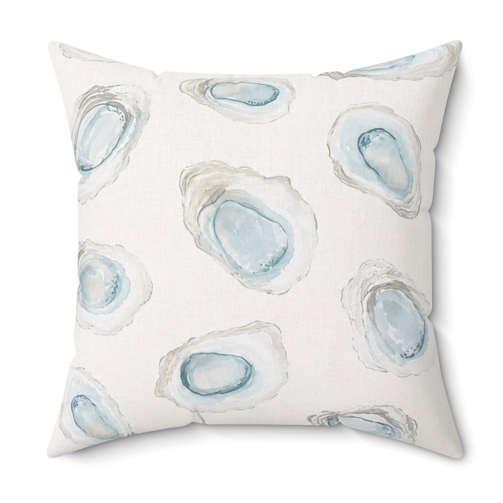 Light blue nautical oyster pattern throw pillow on a neutral couch in a bright coastal home.
