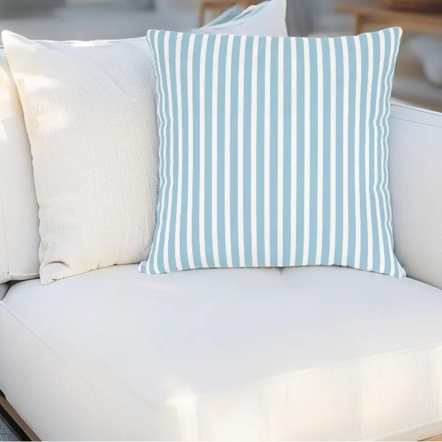 Hampton Stripe Throw Pillow with blue coastal stripes on a white outdoor sofa.