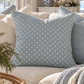 Light blue throw pillow with white polka dots for classic coastal home decor.