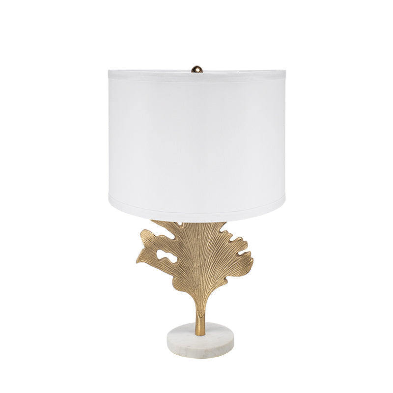Sculptural gold accent lamp with white shade decorating an elegant neutral living room.
