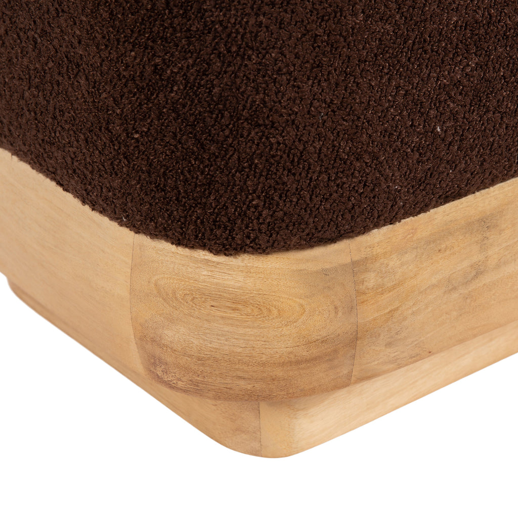 Modern brown ottoman with wooden base styled in a warm living room