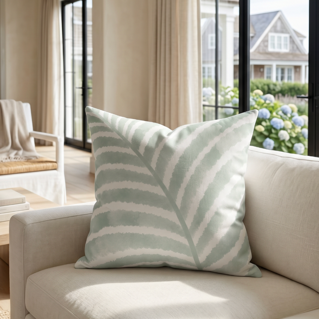 Modern palm leaf throw pillow styled for a serene beach-inspired interior.