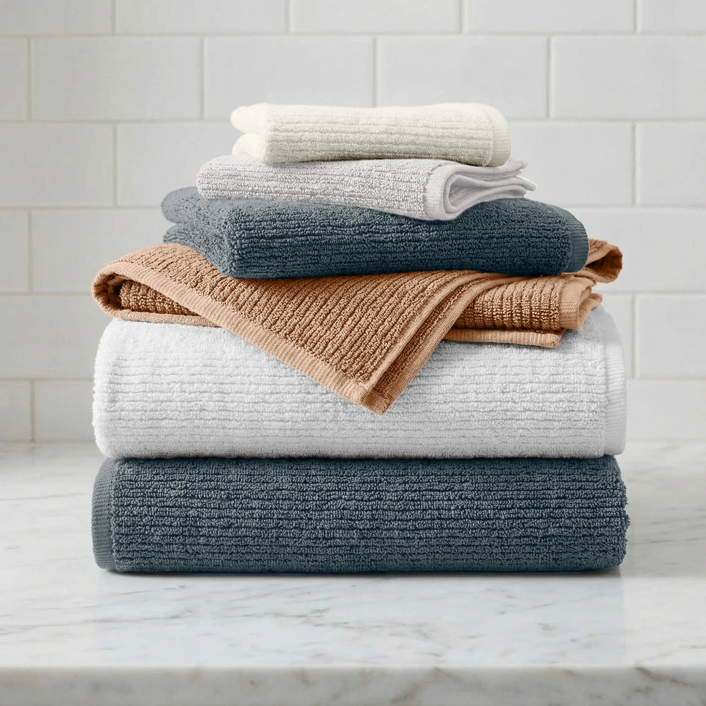 Great Bay Home Turkish Cotton Ribbed 6-Piece Bath Towel Set; white, gray, peach, navy towels stacked on a marble counter