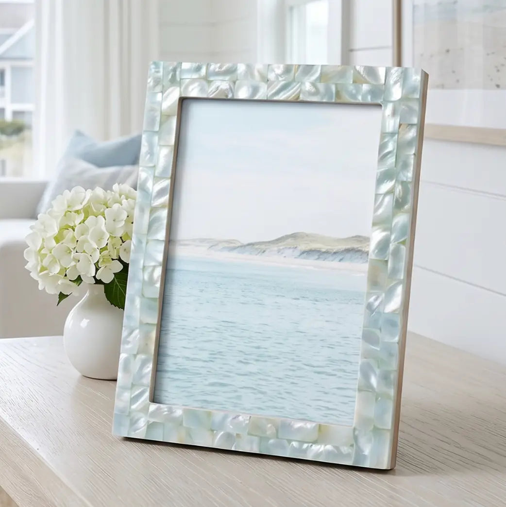 Green mother-of-pearl inlay picture frame on a coastal console table