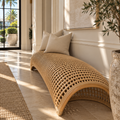 Long natural rattan accent bench styled with solid ivory linen pillows in a bright coastal luxury foyer.