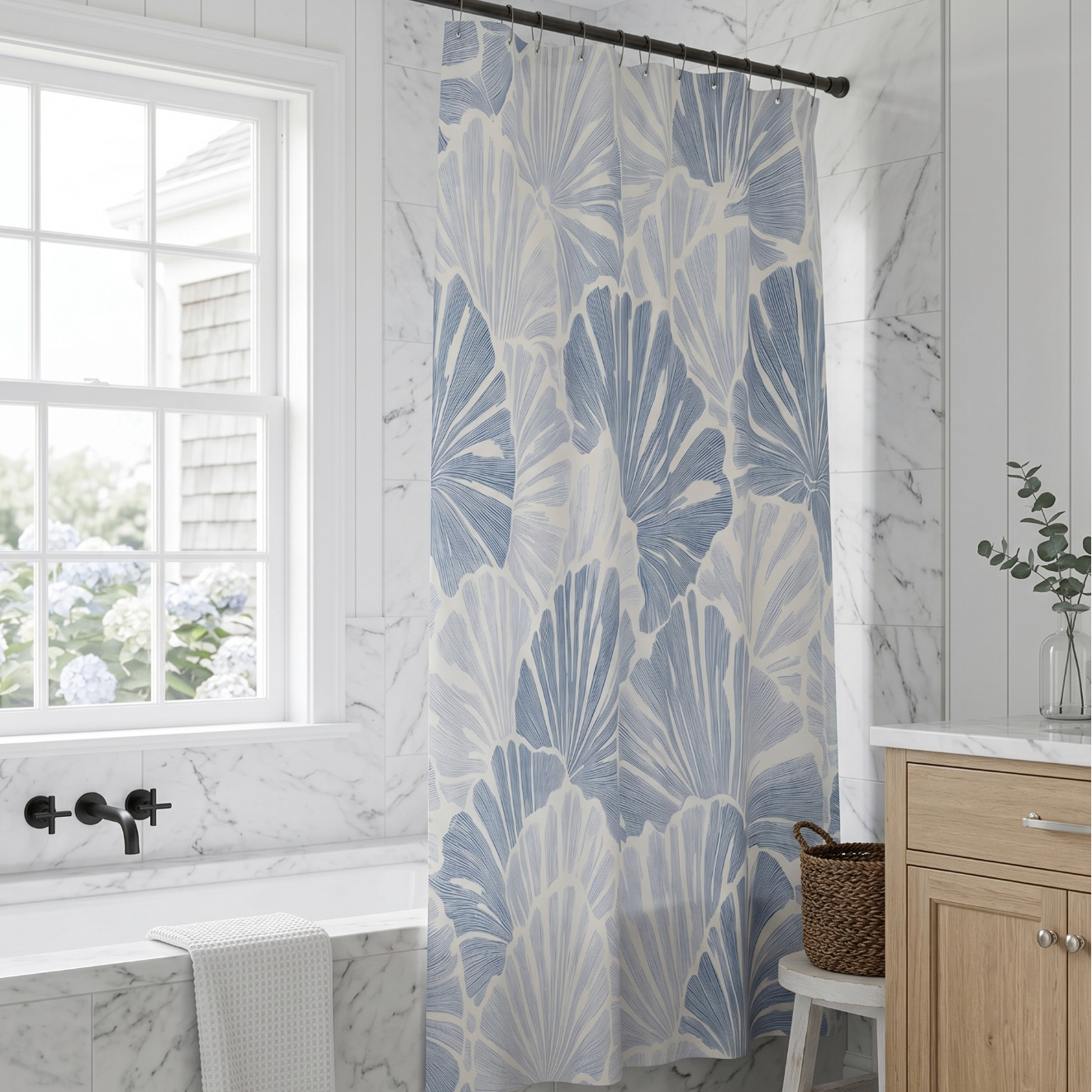 Blue and white coastal fan shell shower curtain creating a seaside feel in a small bathroom