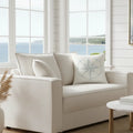 True North Throw Pillow featuring a blue compass rose on cream cushion in a coastal living room.