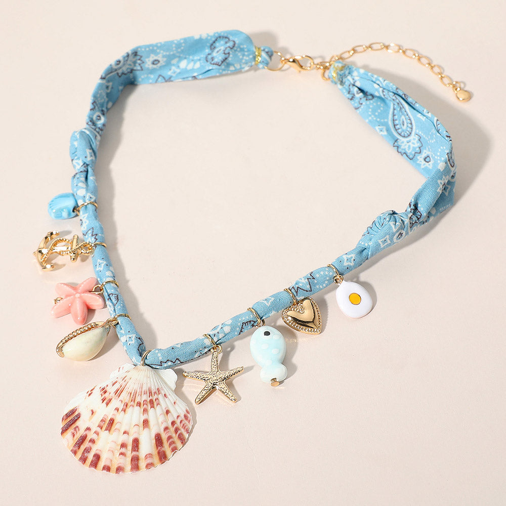Bold fabric statement necklace with seashell, starfish, anchor and heart nautical charms for beach inspired outfits