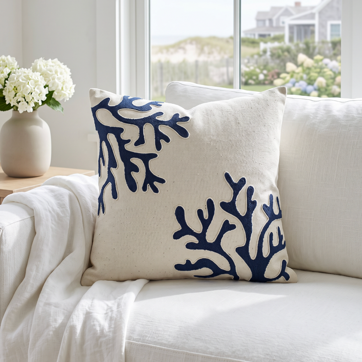 Navy decorative pillow with white embroidered coral branches for a refined coastal look.