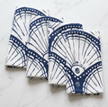 Stacked navy linen napkins with white seashell print for beach house table décor