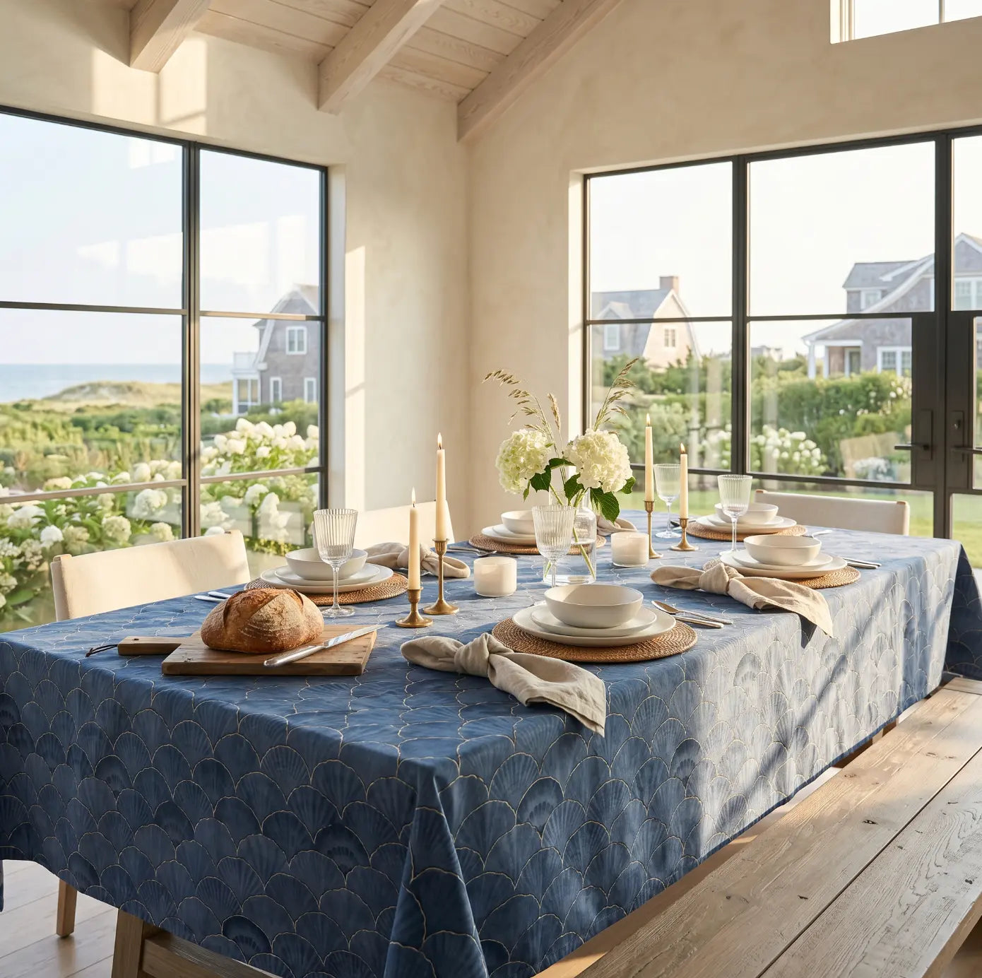 Navy seashell tablecloth adding a bold coastal pattern to a dining table.