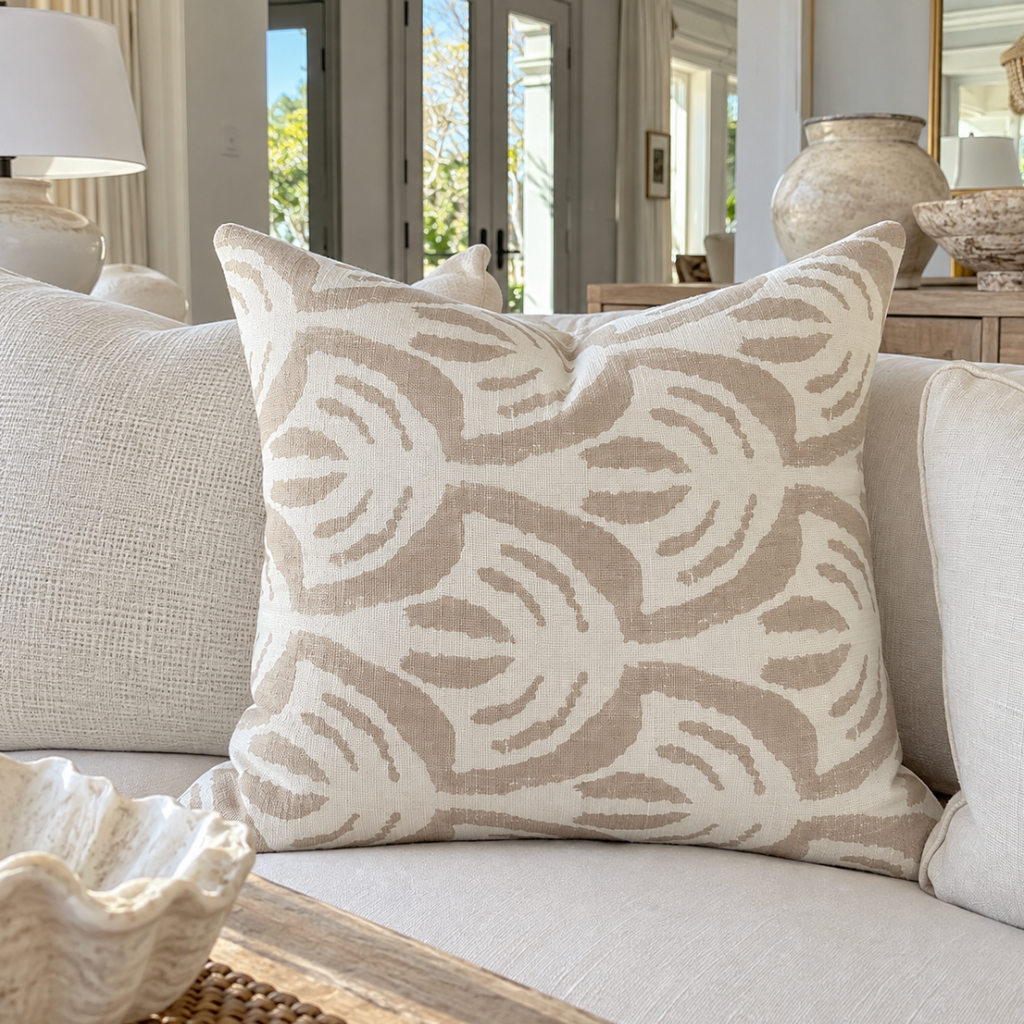 Neutral abstract patterned throw pillow on a cream upholstered sofa.