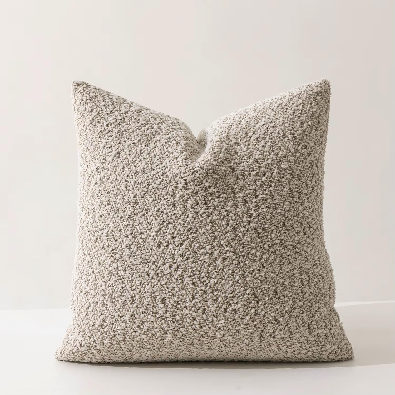 Neutral brown lumbar cushion with a tactile bouclé cover, perfect for everyday seating.