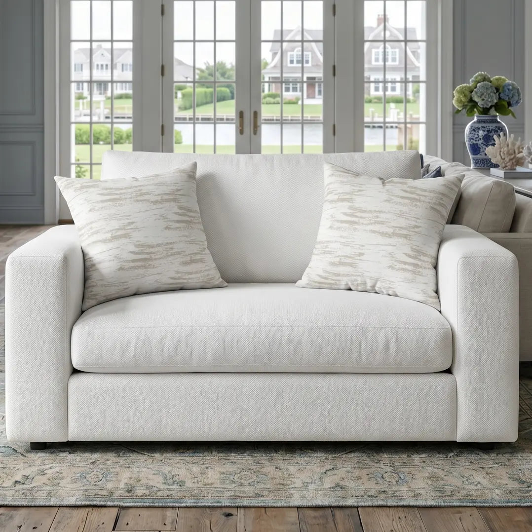 Neutral brushstroke accent pillow on an armchair in a contemporary living room