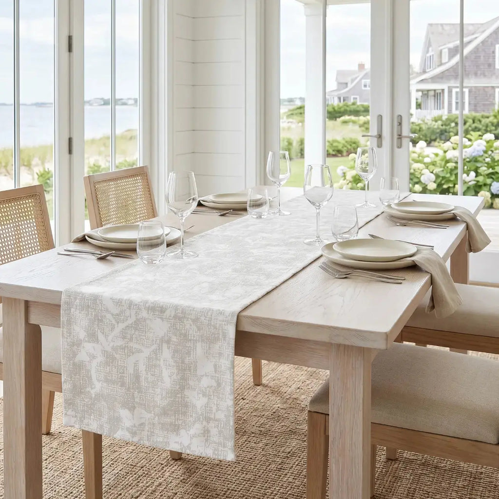 Neutral floral table runner in a relaxed coastal farmhouse dining room.