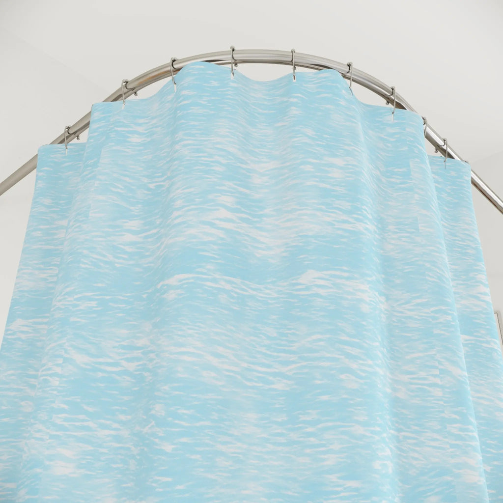 Coastal Tide Shower Curtain in light blue water texture, hung on curved rod for calming bathroom decor.