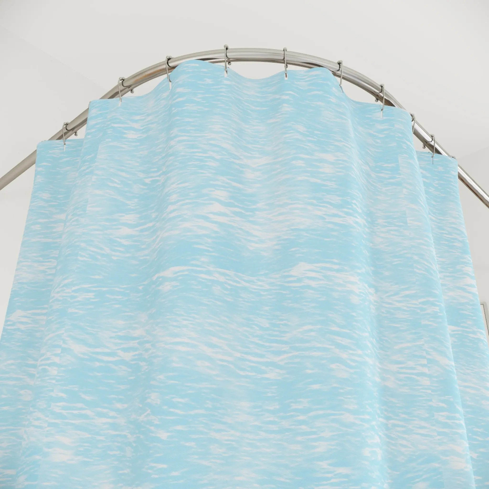 Coastal Tide Shower Curtain in light blue water texture, hung on curved rod for calming bathroom decor.