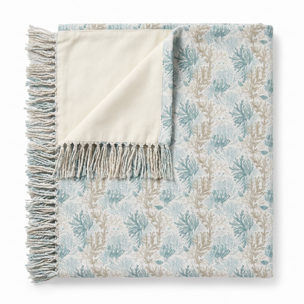 Light aqua and sand coral patterned throw creating a refined ocean‑inspired accent in a beach house.