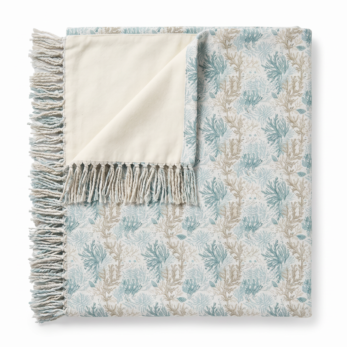 Light aqua and sand coral patterned throw creating a refined ocean‑inspired accent in a beach house.