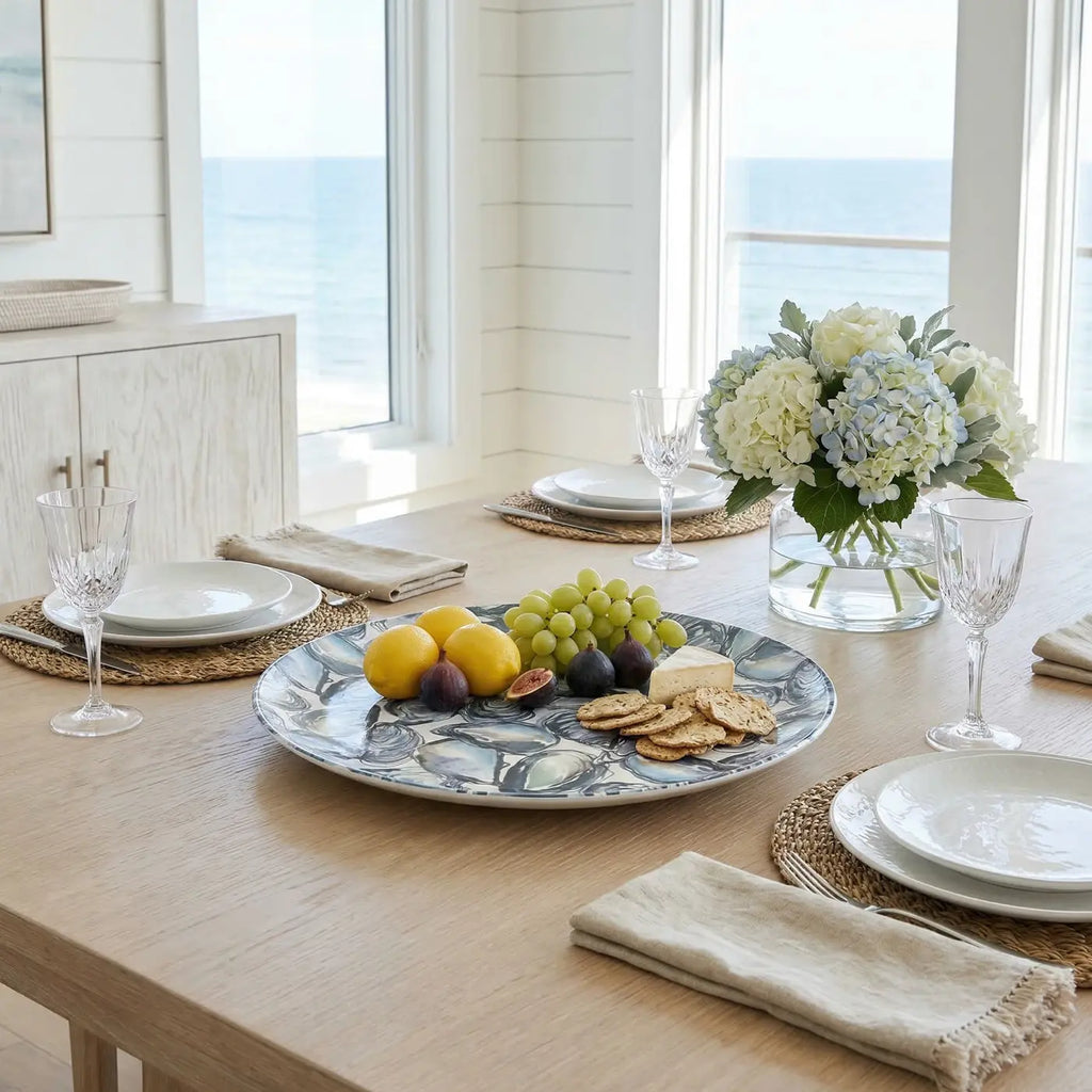 Oyster Serving Tray centerpiece on a marbled blue tray with lemons, grapes, figs, cheese, and crackers.