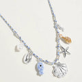 Pearl seashell starfish seahorse charm necklace with twisted fabric chain styled as a coastal statement accessory.