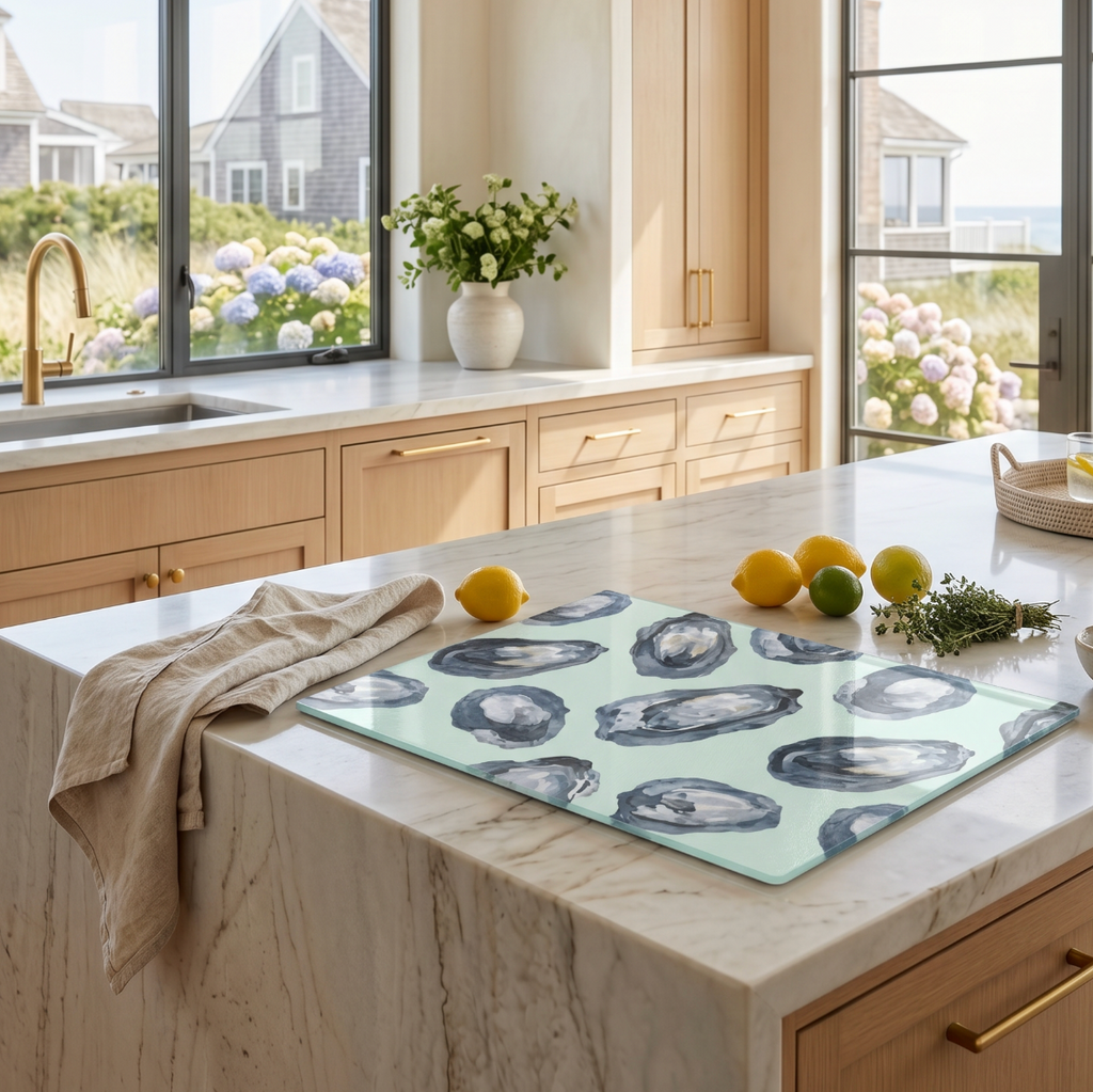 Oyster navy blue glass cutting board and serving board used as a coastal cheese and charcuterie tray on a dining table