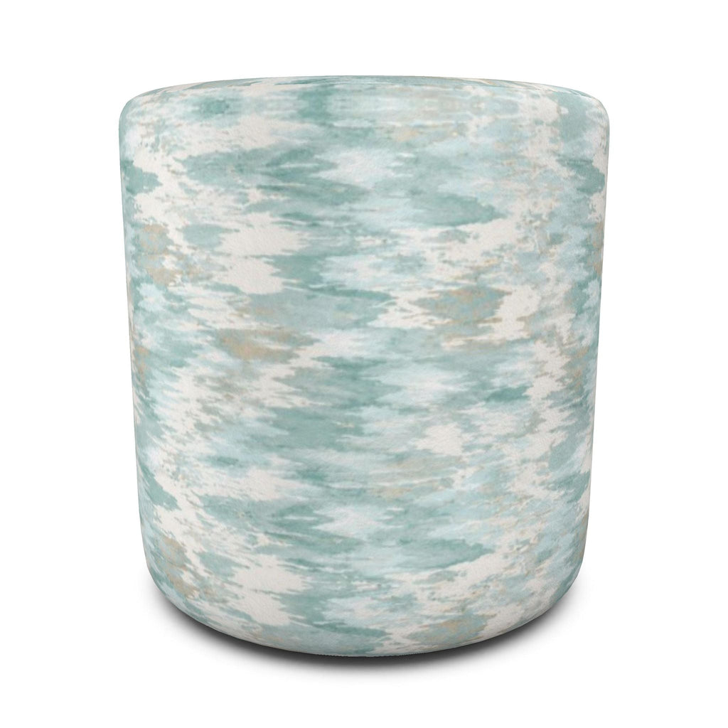 Blue abstract-pattern round ottoman paired with white furniture, natural wood, and seaside-inspired décor.