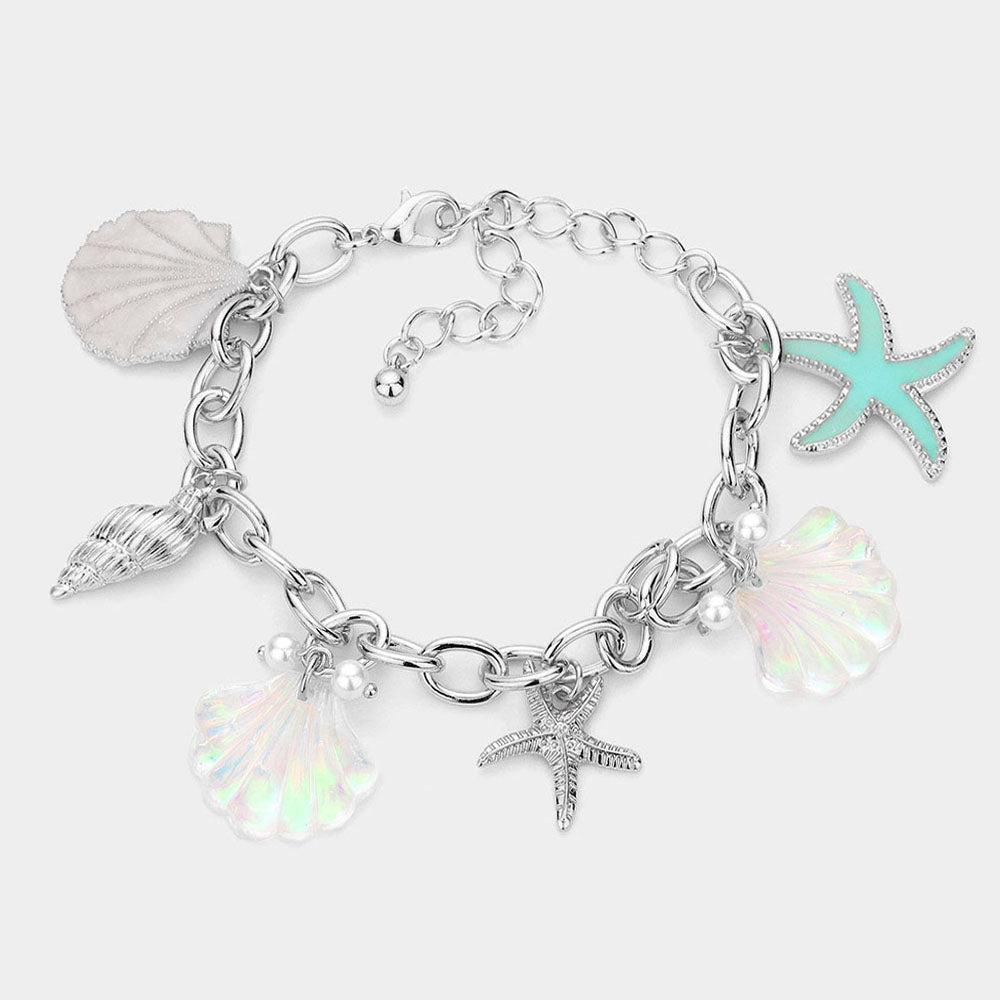 Coastal shell conch starfish pearl charm bracelet shown as beach inspired everyday jewelry.