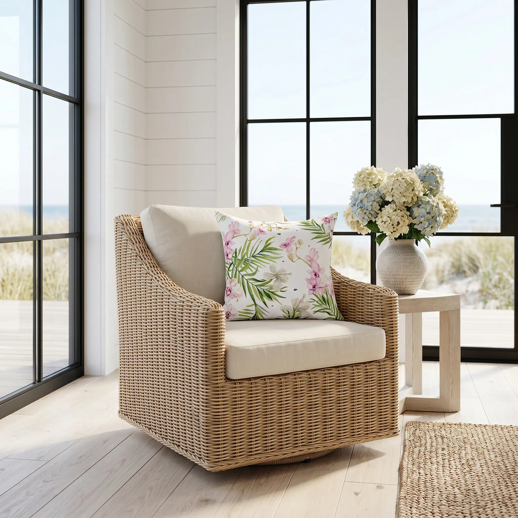 Pink and green tropical throw pillow on a sofa in a coastal living room