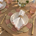 Pink woven placemats with a decorative pinwheel pattern.