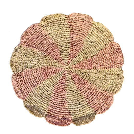 Pink woven pinwheel placemats styled on a bright dining table.
