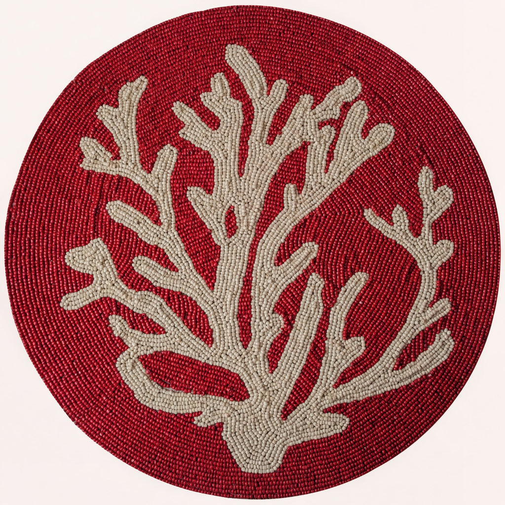 Red coral dining placemat creating an elevated coastal tablescape.