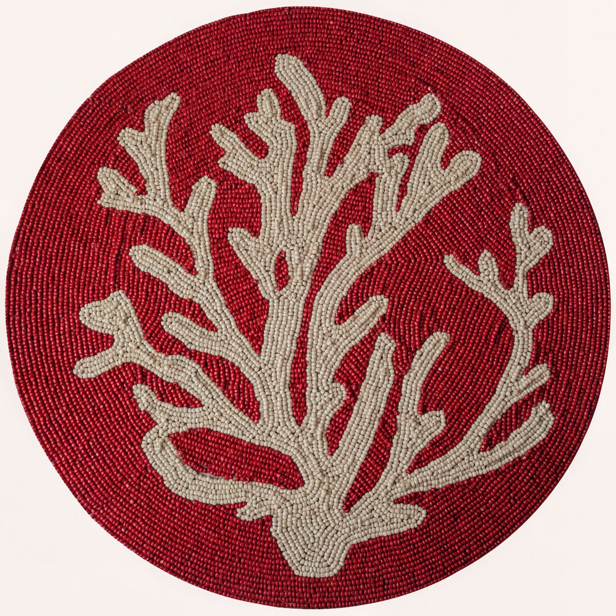 Red coral dining placemat creating an elevated coastal tablescape.