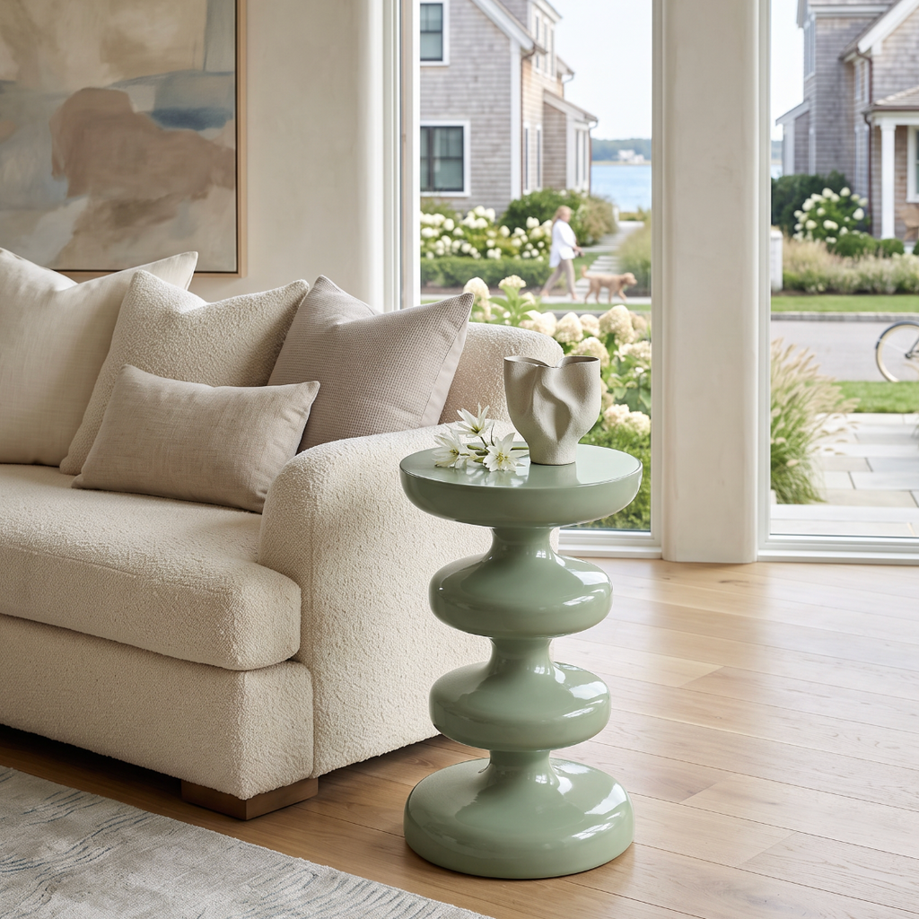 Coastal cottage drink table in muted sage green with a bold sculptural pedestal silhouette.